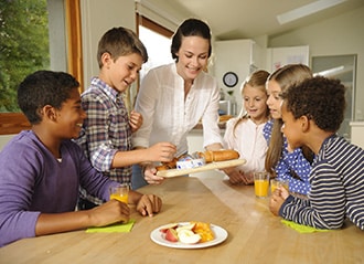 Woman & kids snacking on Bel cheese